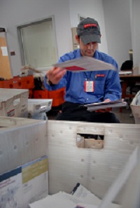 University Mail clerk Kenneth Cash flips a letter into the correct bin while sorting mail. PHOTO BY ROGER WINSTEAD
